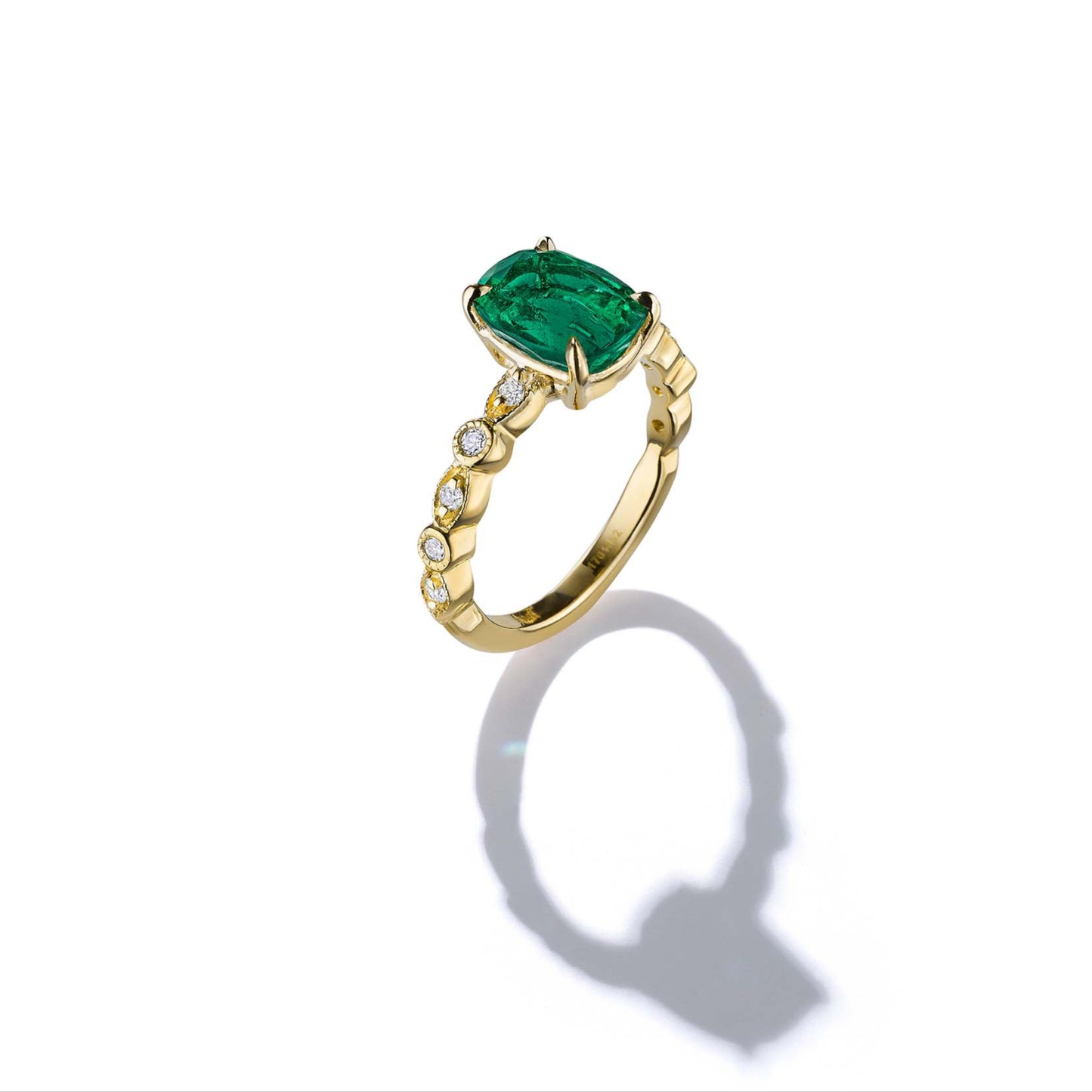 Gold ring with a green gemstone on a white background