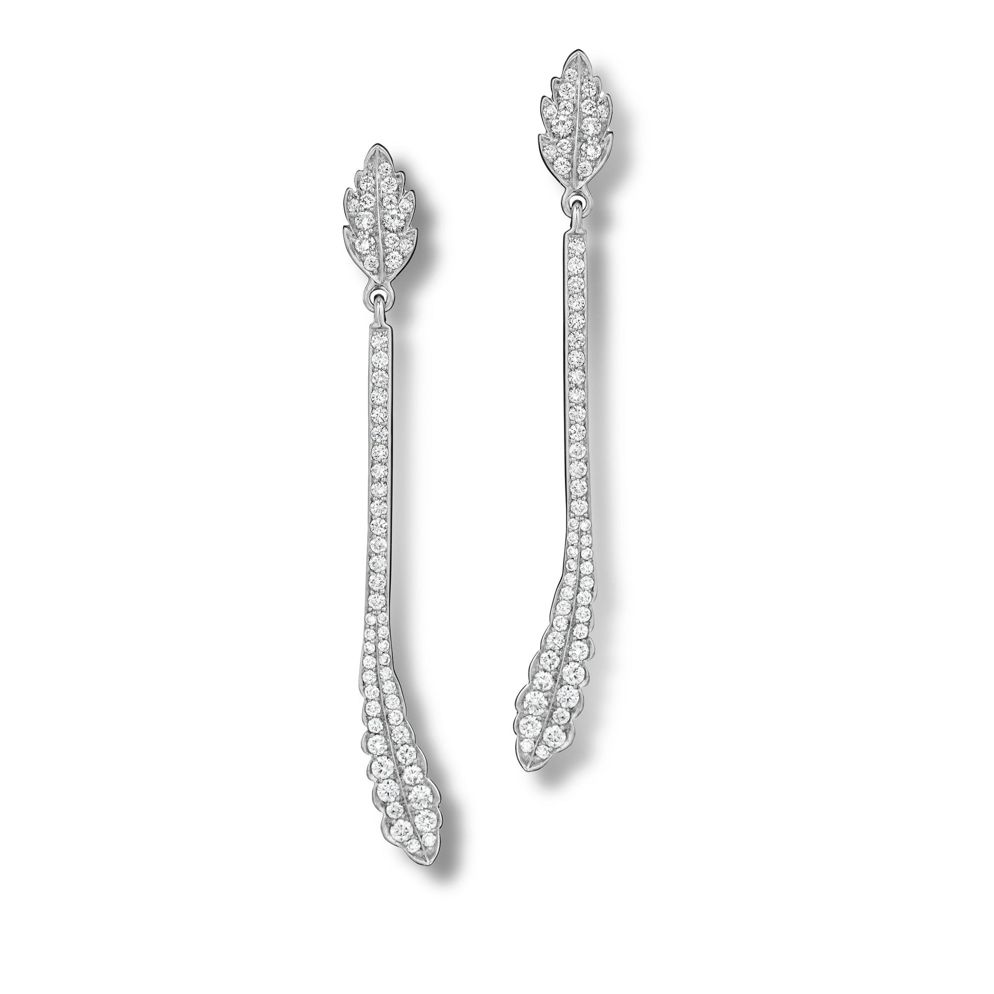 Pair of white gold earrings with intricate designs on a white background