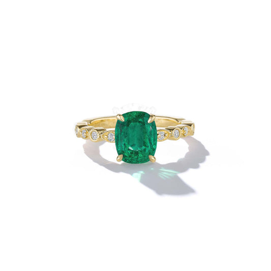 Gold ring with a green gemstone on a white background