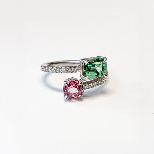 Ring with pink and green gemstones on a white background