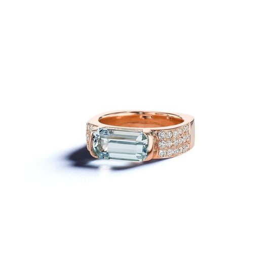 Rose gold ring with emerald-cut gemstone on a white background